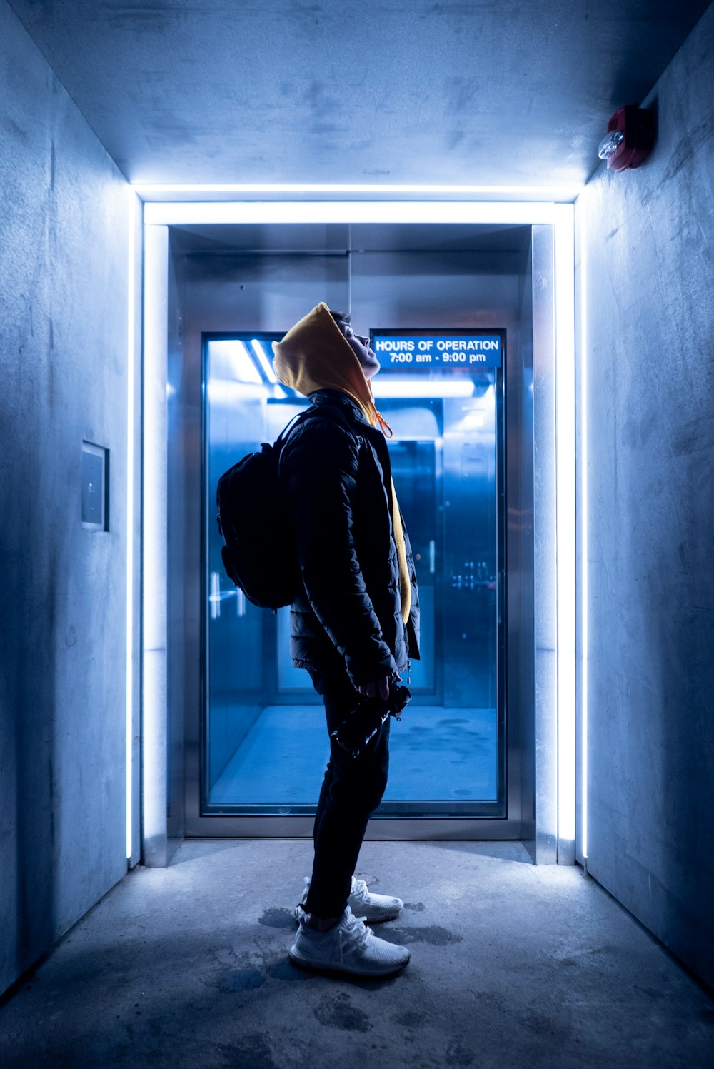 standing man wearing black and brown zip-up hoodie