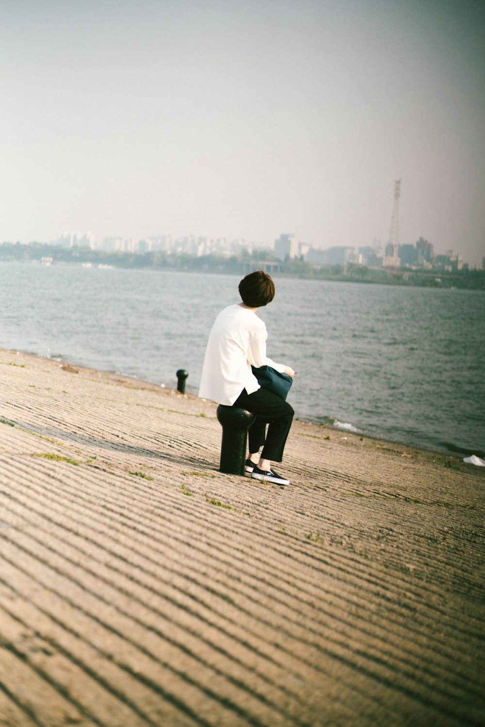 woman sitting near sea during daytime