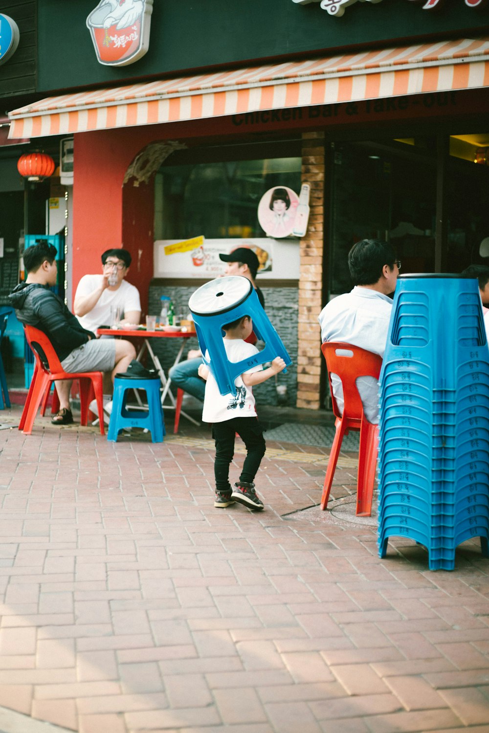 boy holding blue plastic stool