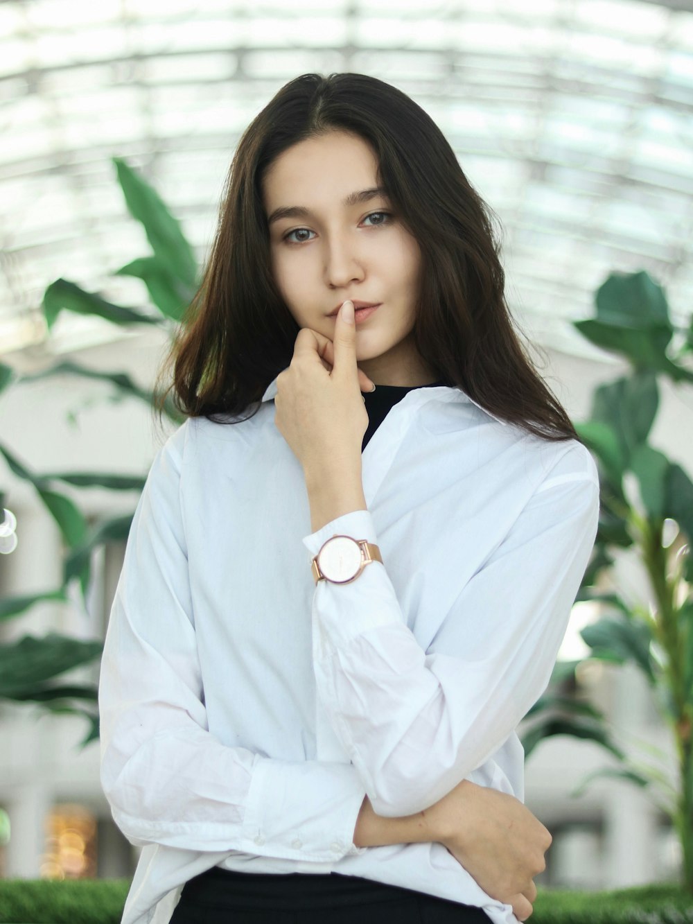 woman in white dress shirt touching lips