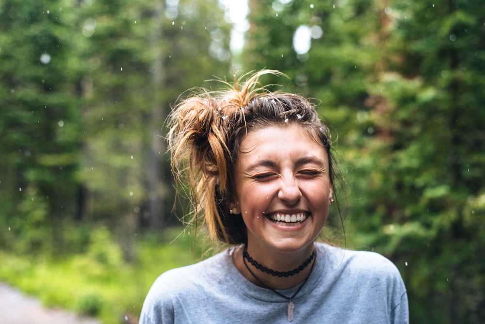 woman smiling near tree outdoor during daytime