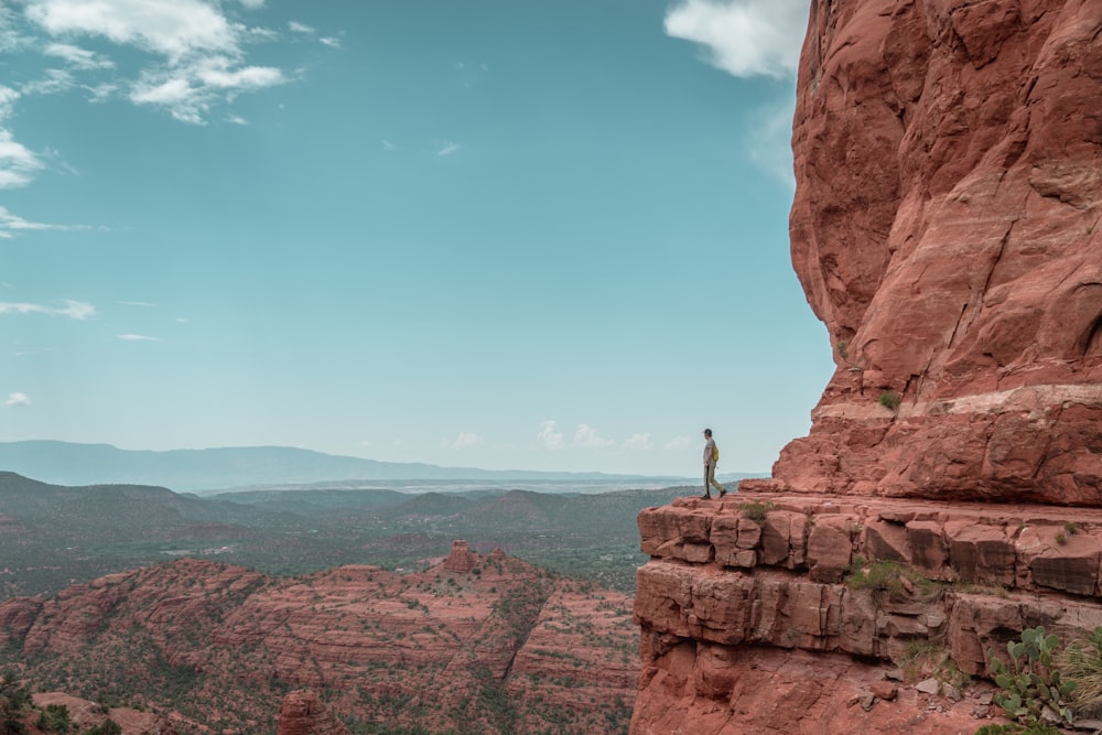 man standing on brown cliff