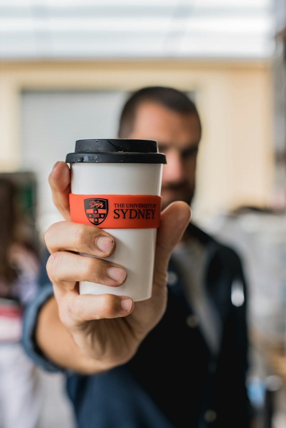 man holding sydney drinking cup