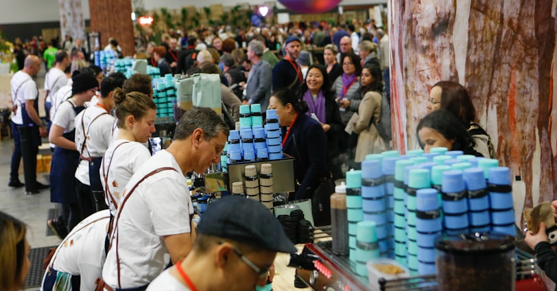 man serving on desk near people lining up