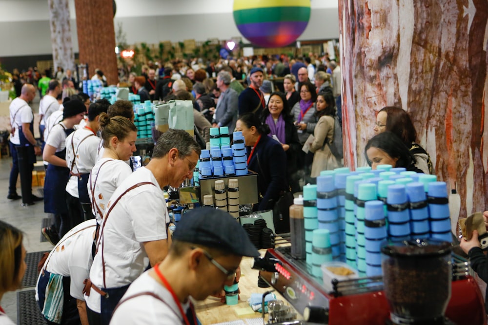 man serving on desk near people lining up