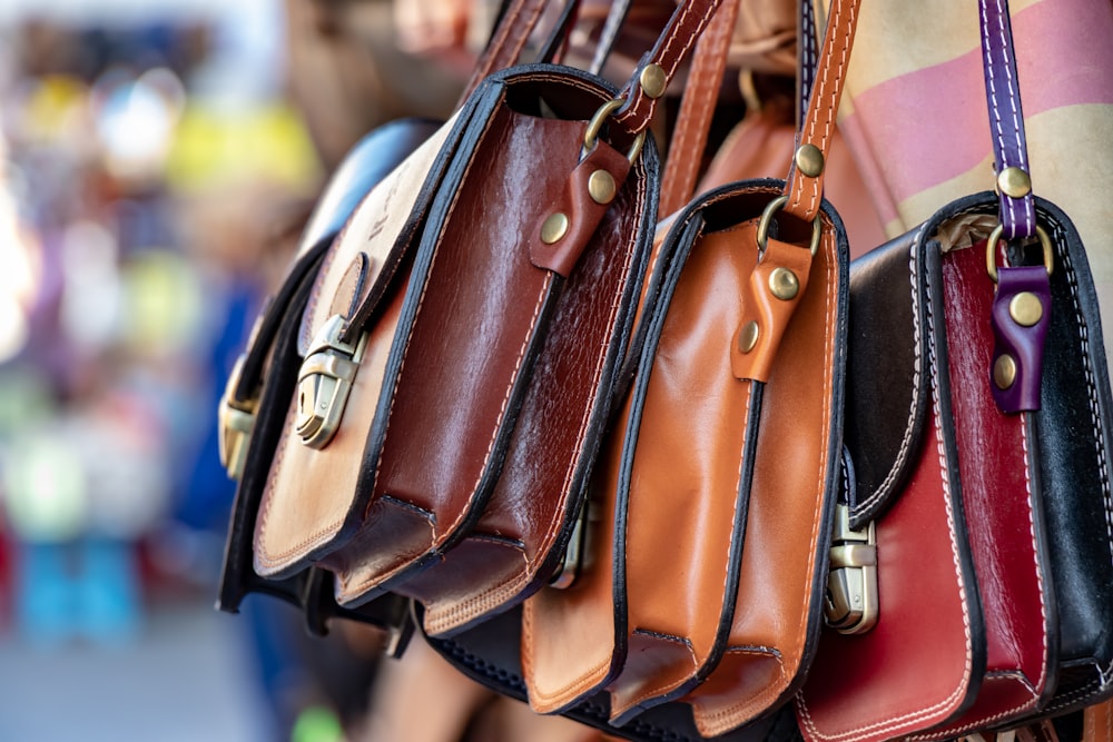 three assorted-color leather crossbody bags