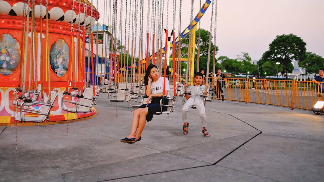 man and woman riding carousel