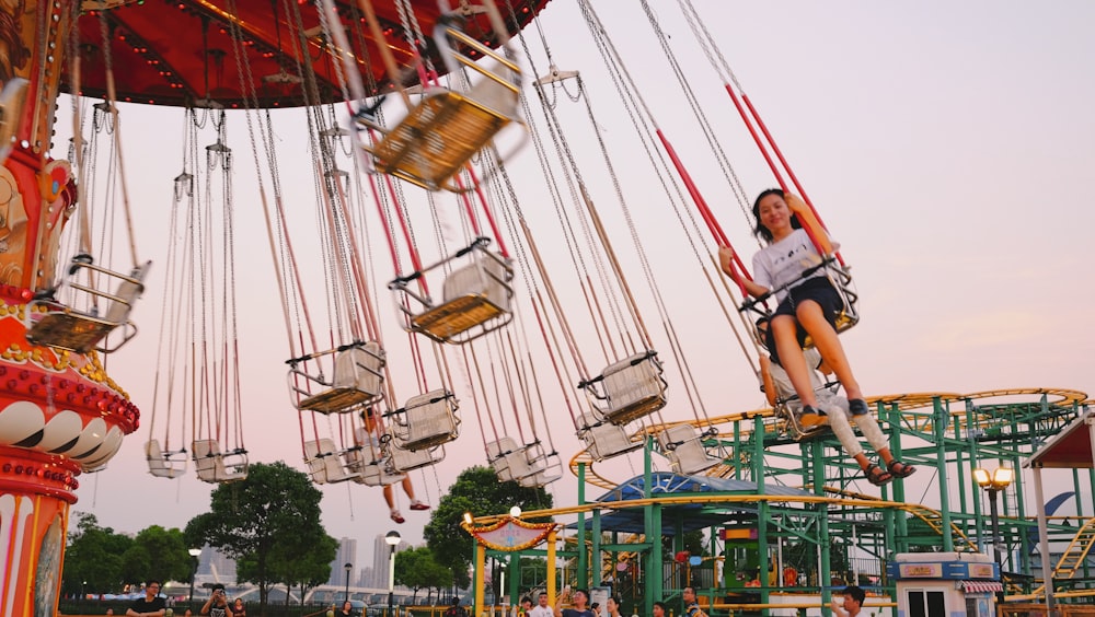 woman riding on chair swing during daytime