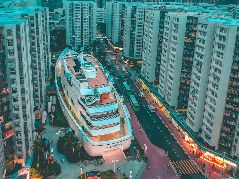 white boat building surrounded with high-rise buildings