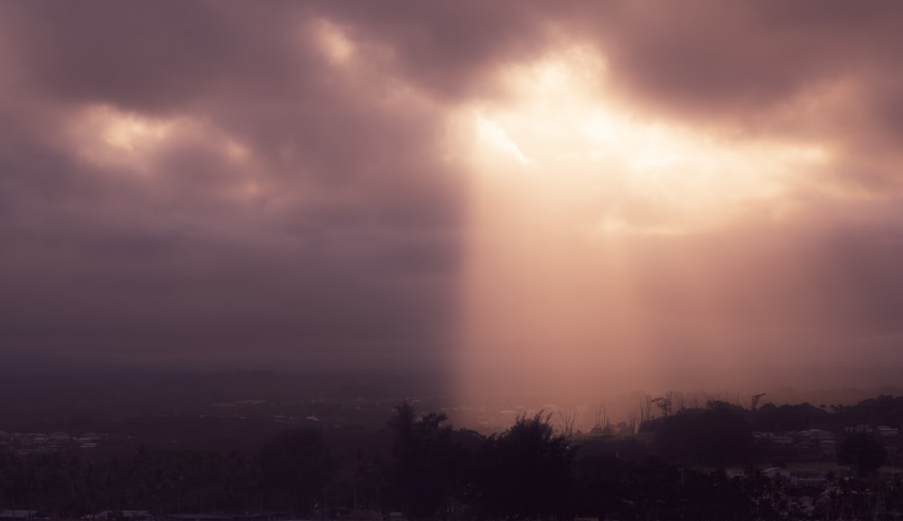 Die Sonne scheint durch die Wolken über einer Stadt