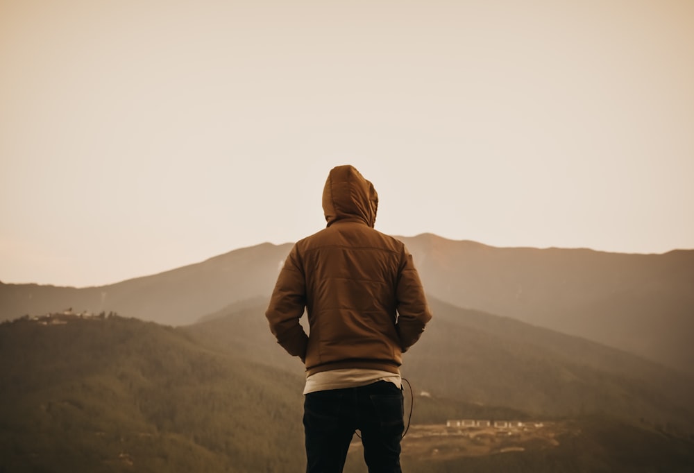 personne portant un sweat à capuche marron