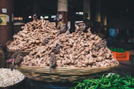 Fresh ginger roots laid out on woven baskets at a local market.
