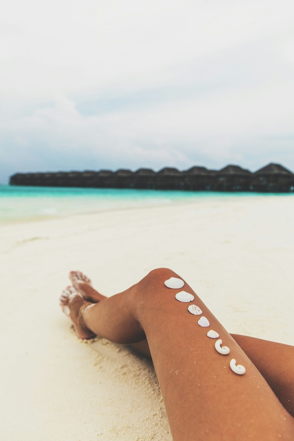 person sitting down on beach sand