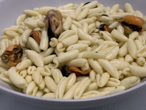 A close-up of mussels drizzled with a bold Italian-inspired sauce.