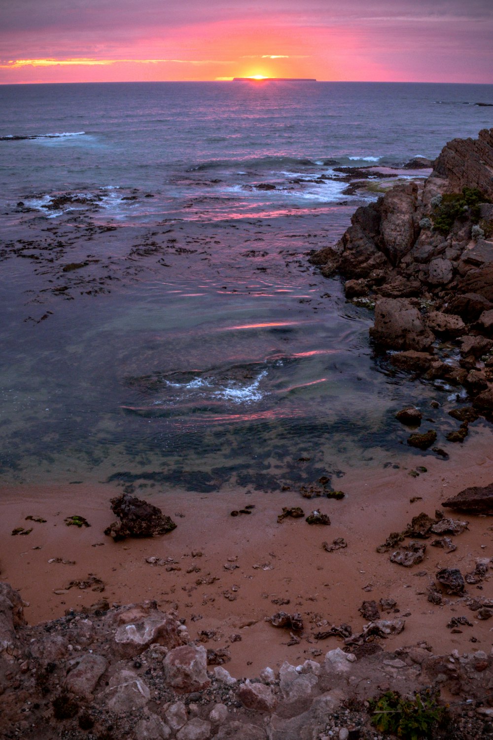 water smashing rocks on seashore during sunset