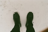 A close-up of beige heeled boots on a snowy surface.