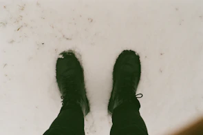 A pair of stylish snow boots on a snowy surface.