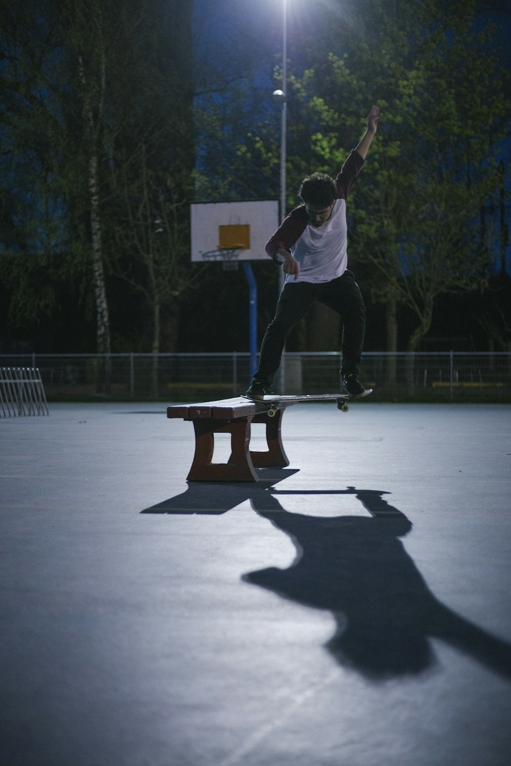 man doing skateboard stunt on bench