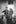grayscale photography of two people raising their hands