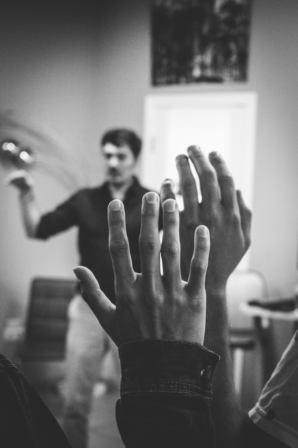 fotografia em tons de cinza de duas pessoas levantando as mãos