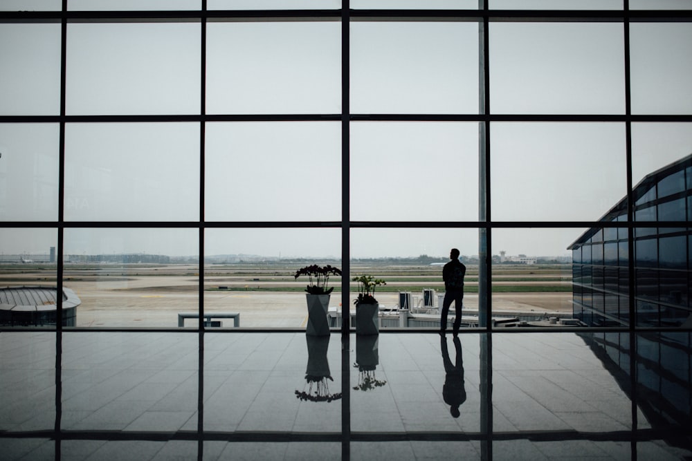 man standing near glass window