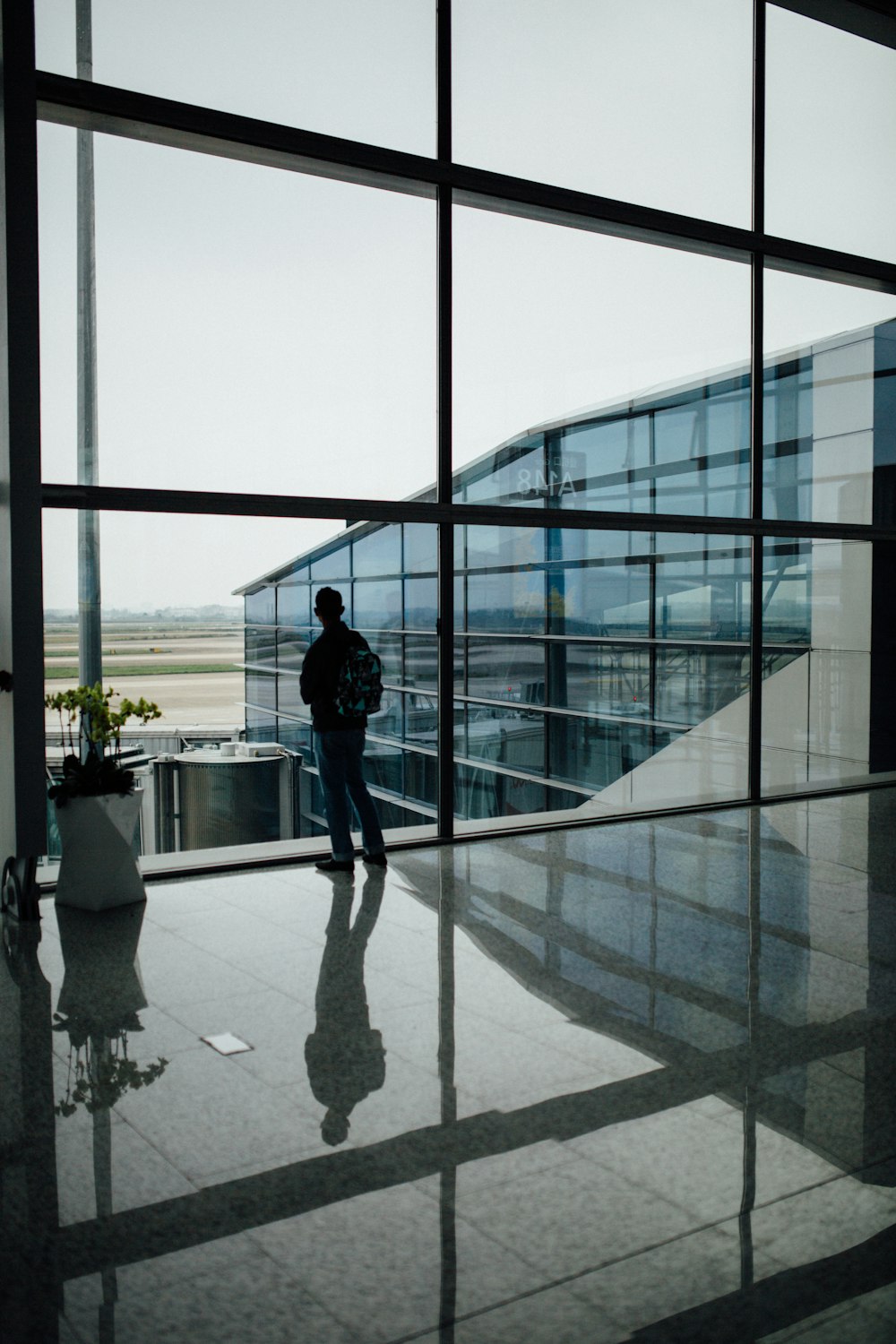 man standing near glass window