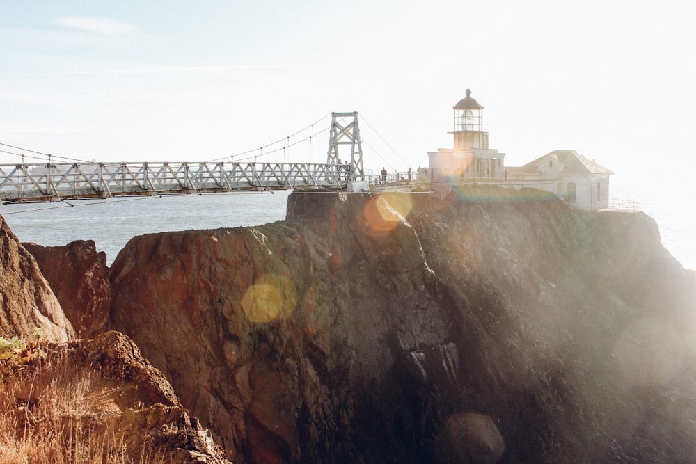 white bridge on rock formation during daytime