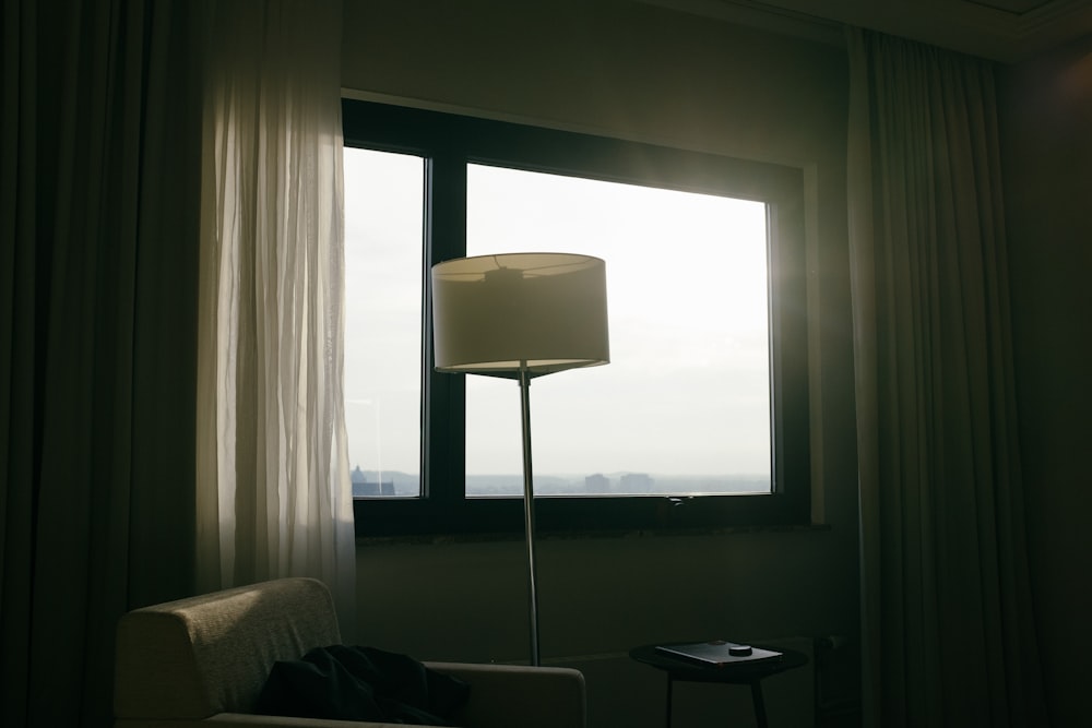 창문 근처의 회색과 흰색 플로어 램프