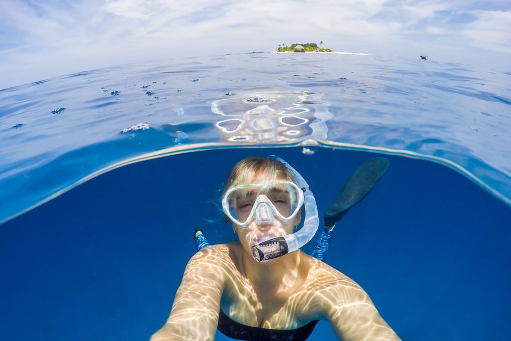 mujer bajo el agua usando snorkel