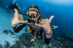 man underwater making hand signs