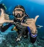 man underwater making hand signs