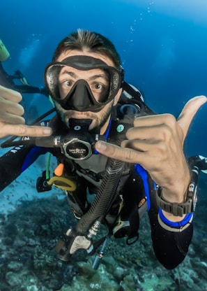 man underwater making hand signs