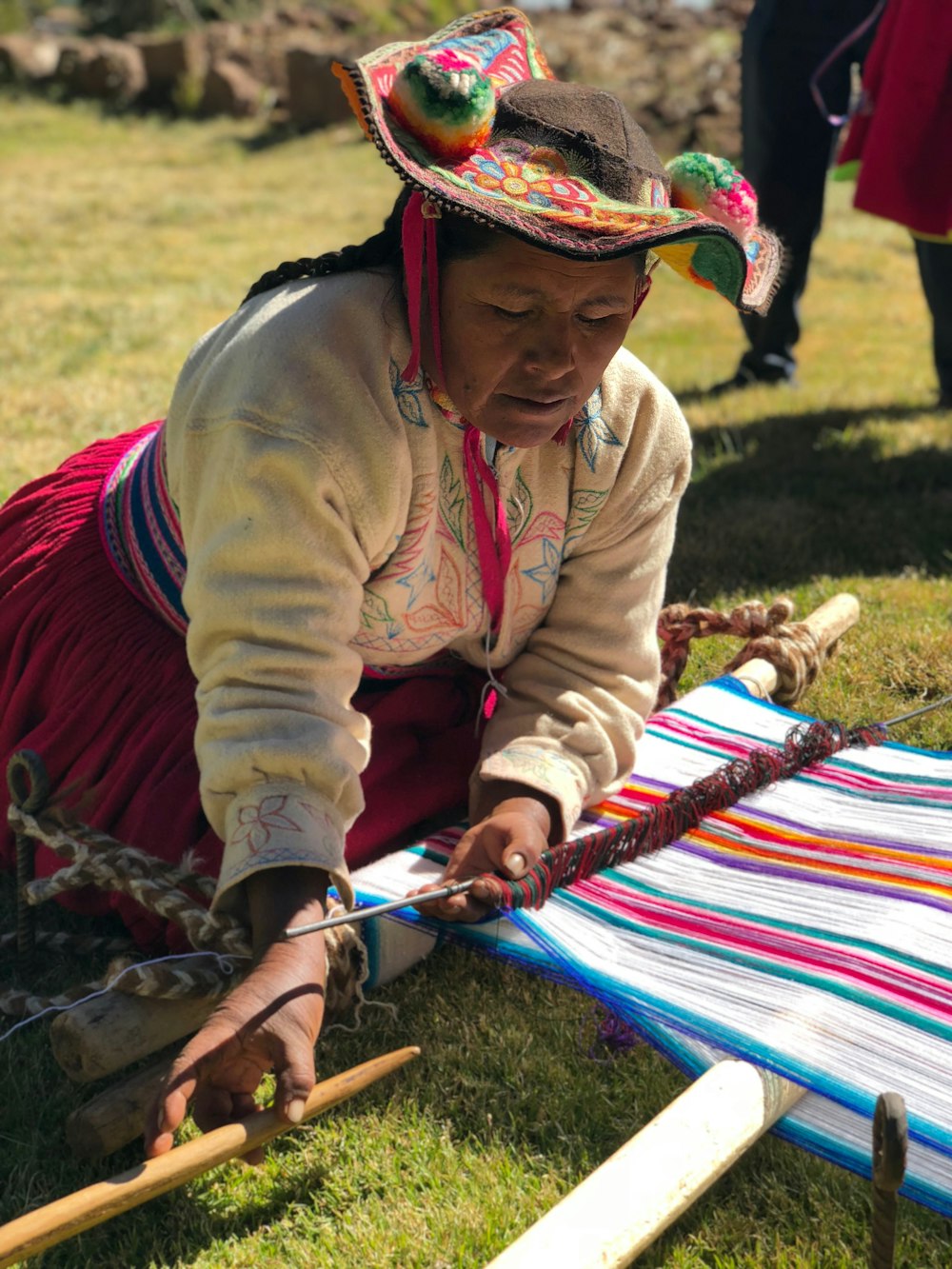 woman weaving multicolored striped cloth