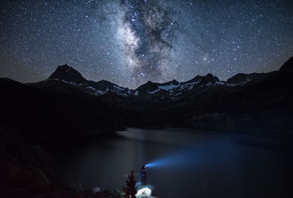 calm body of water near mountain view at night