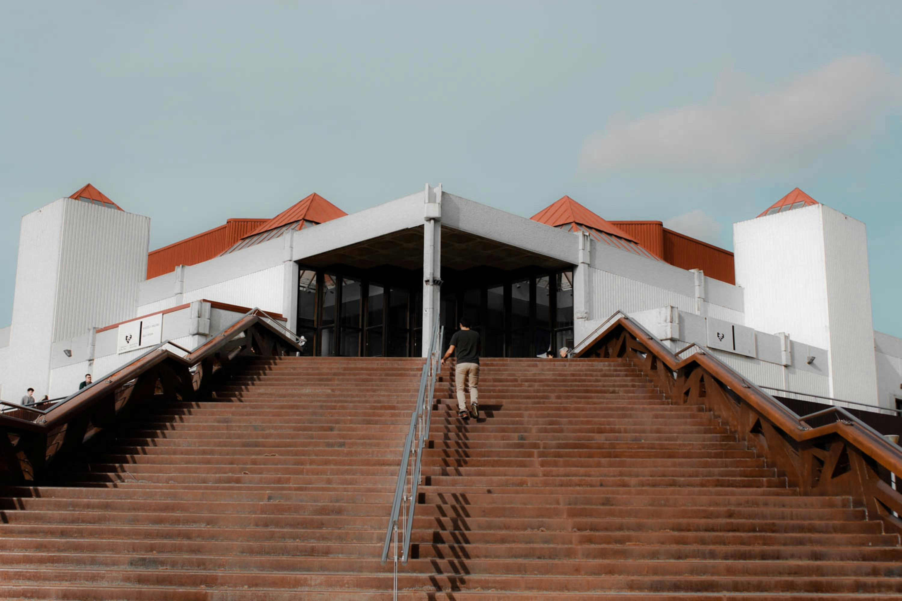 Person On Stair Near White And Orange Building Photo Free
