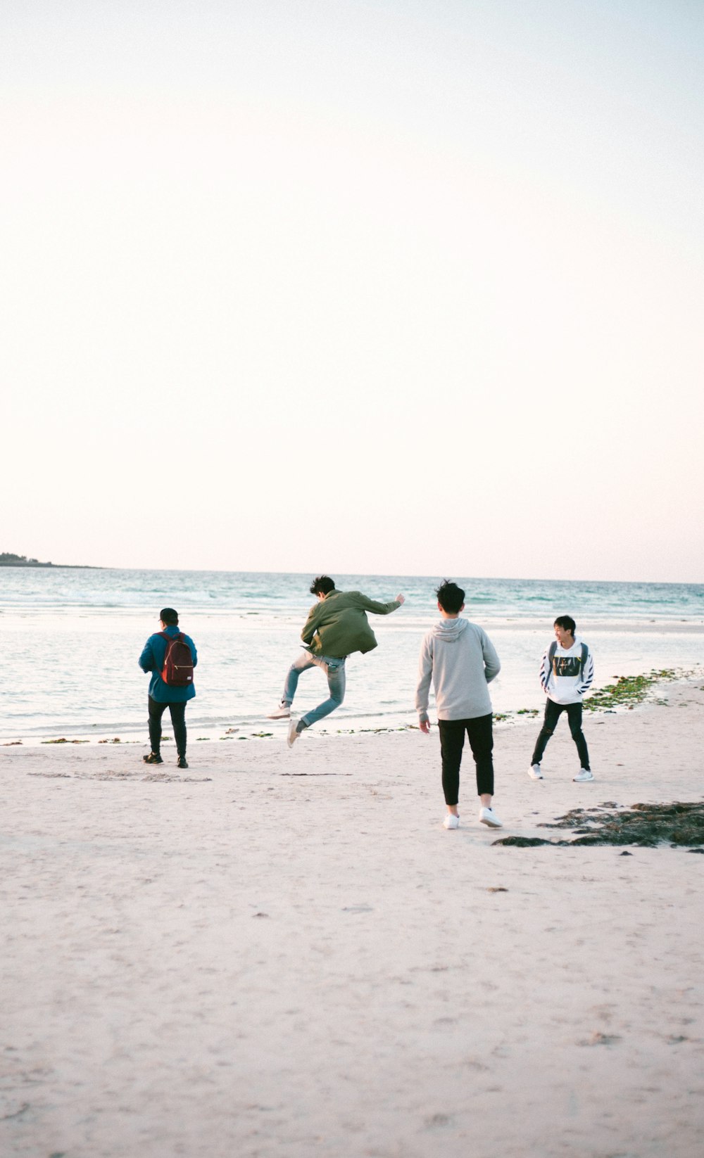 four persons near shore at daytime