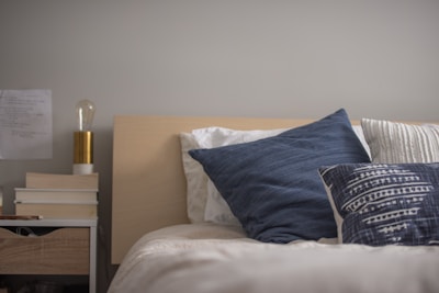 A cozy bedroom setup featuring a neatly made bed with fluffy pillows.