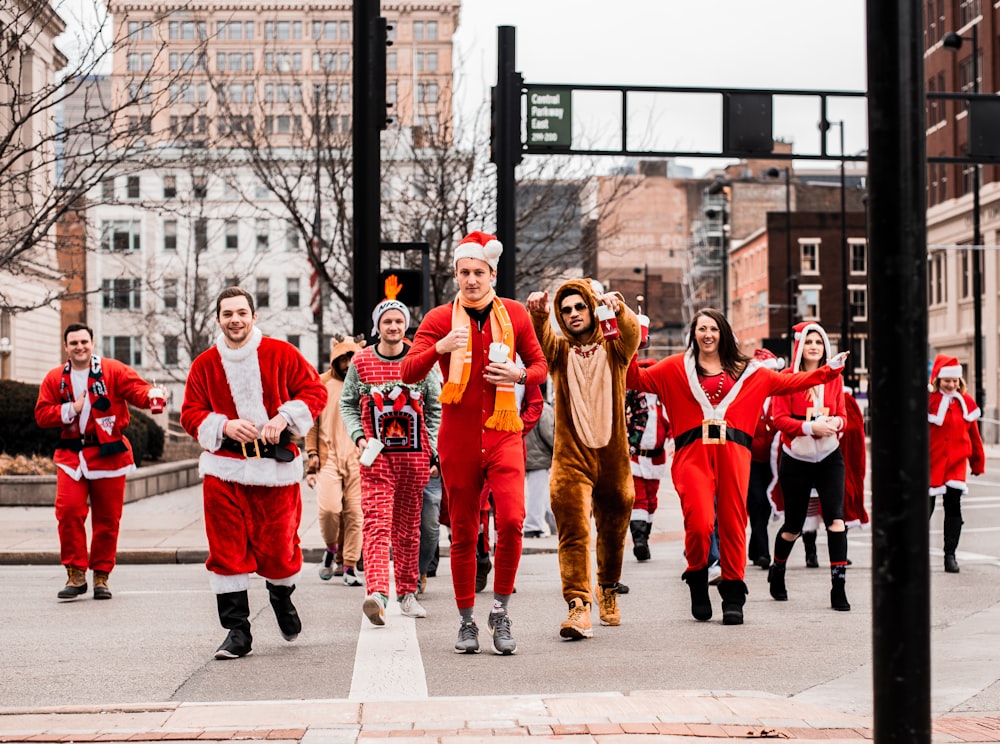 people in Santa Claus outfit marching down the street during daytime