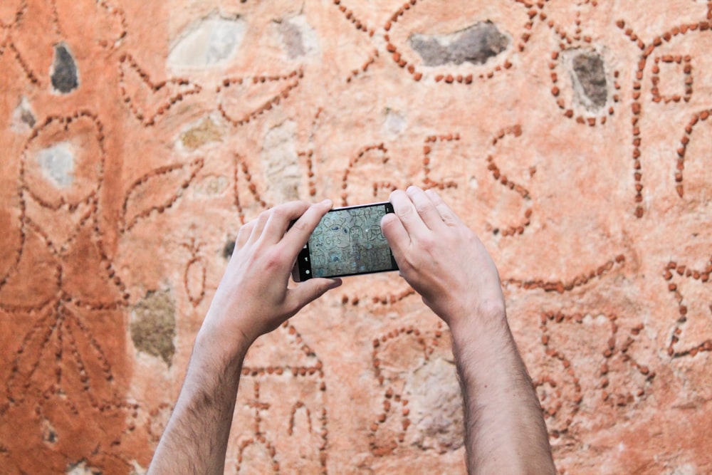 person taking picture of wall