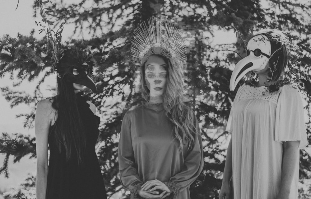 three women standing with masks