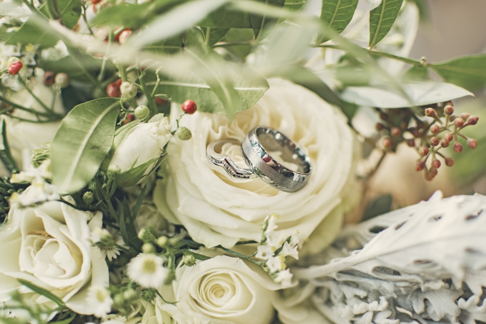 silver-colored ring on white rose flower\