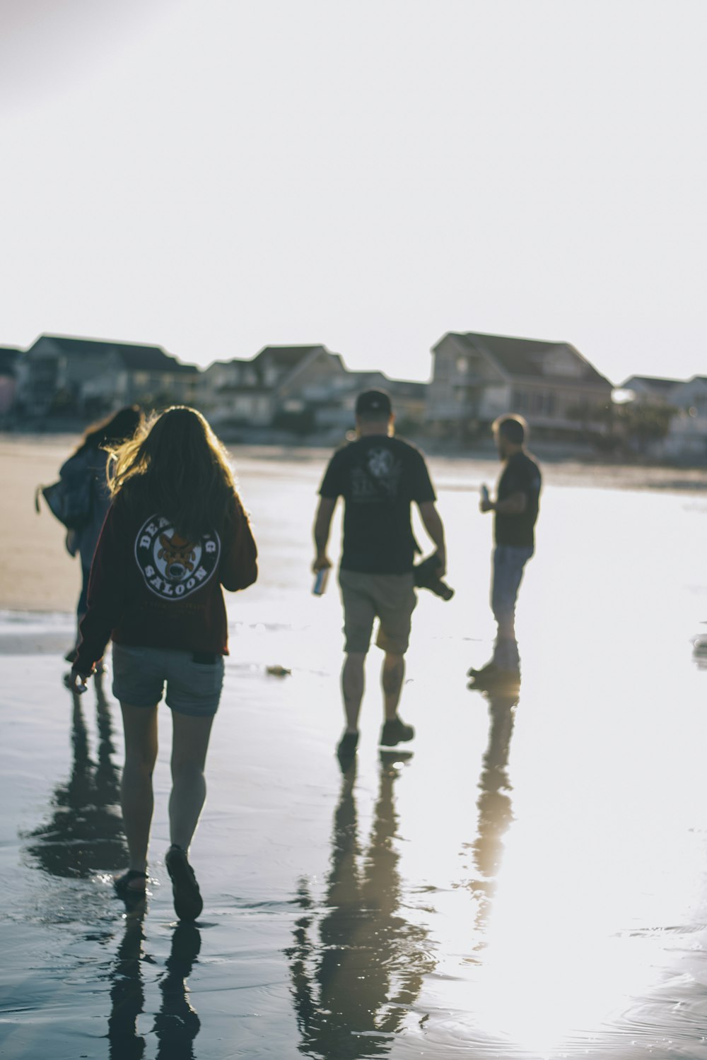 four people walking on wet ground