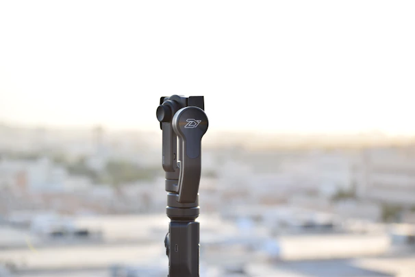 Close-up of a gimbal stabilizer with reflections of purple and black glassmorphism effects.