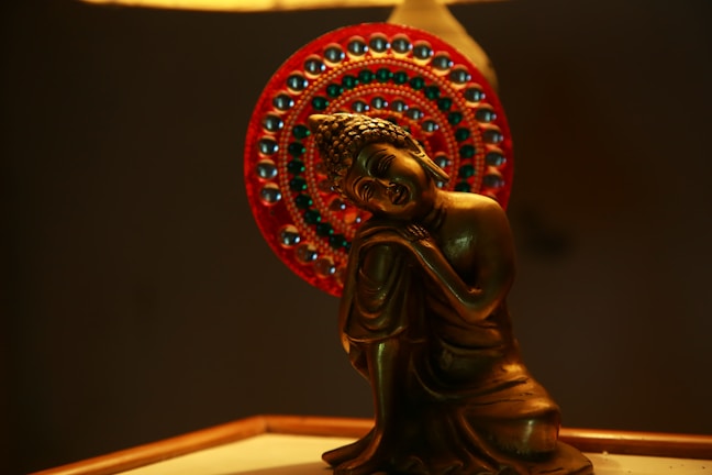 A serene bronze lotus sculpture illuminated softly.