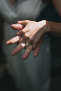 Close-up of intertwined hands from a couple in soft natural light.