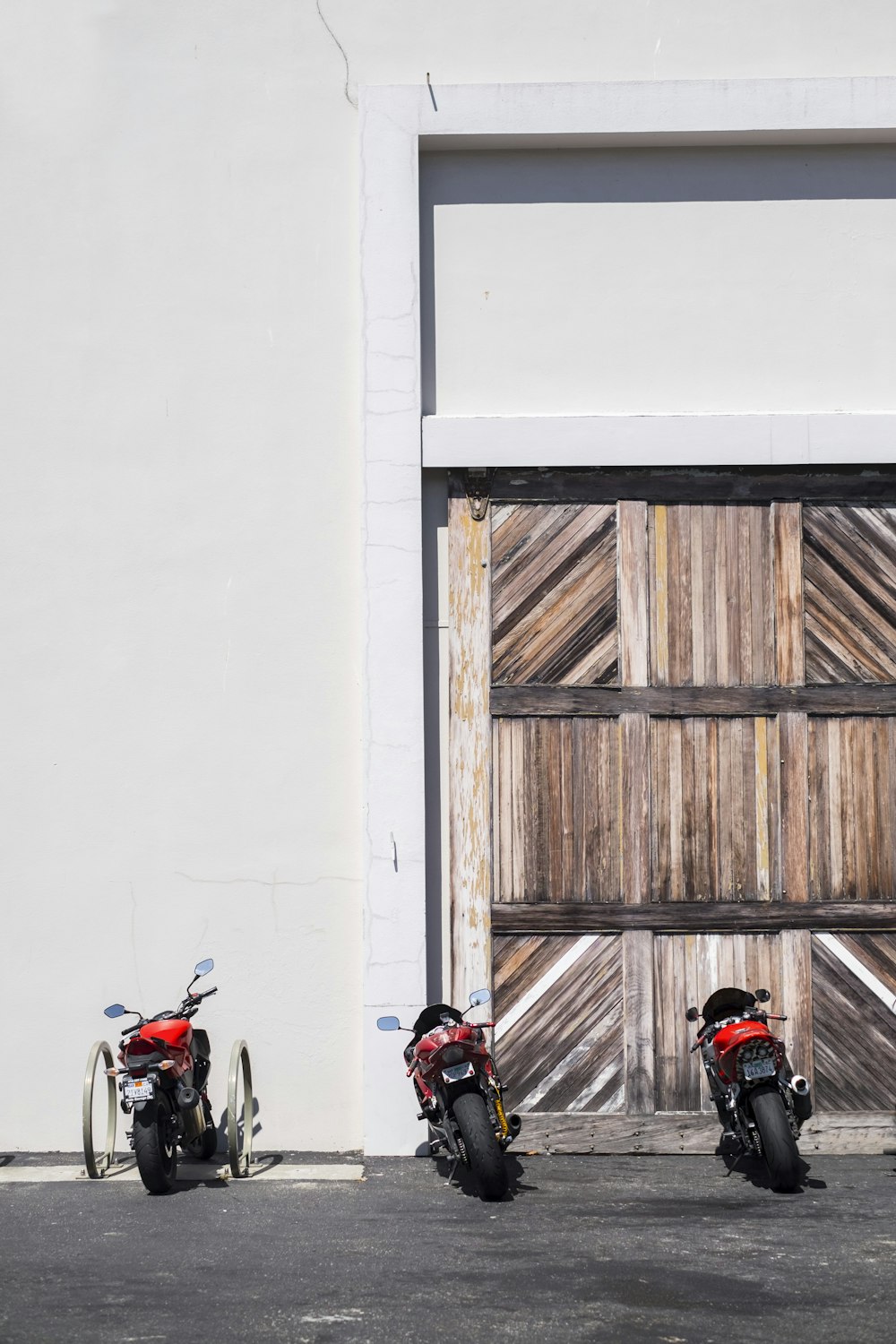 three black and red sports bike parked near gate