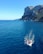 A small group relaxing on a luxury boat with clear blue waters in the background.