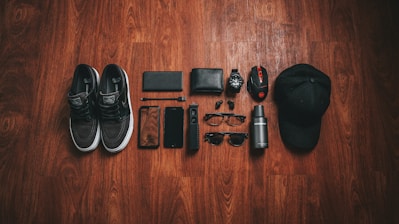 pair of black-and-white low-top sneakers beside black smartphone case