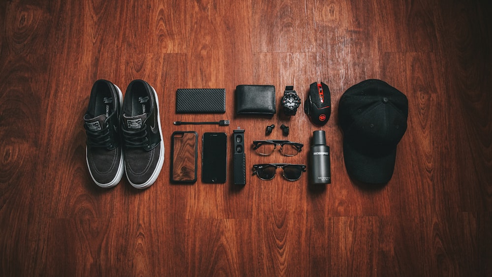 pair of black-and-white low-top sneakers beside black smartphone case