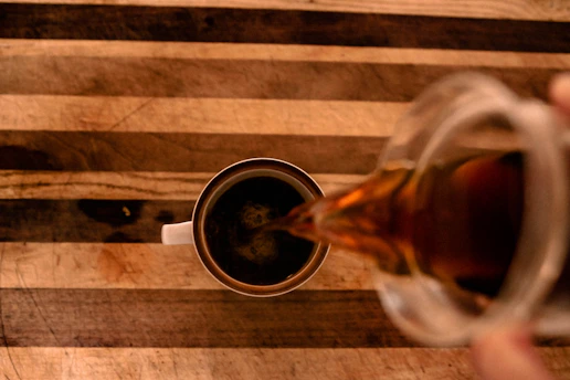 liquid poured on round white mug on top of brown table